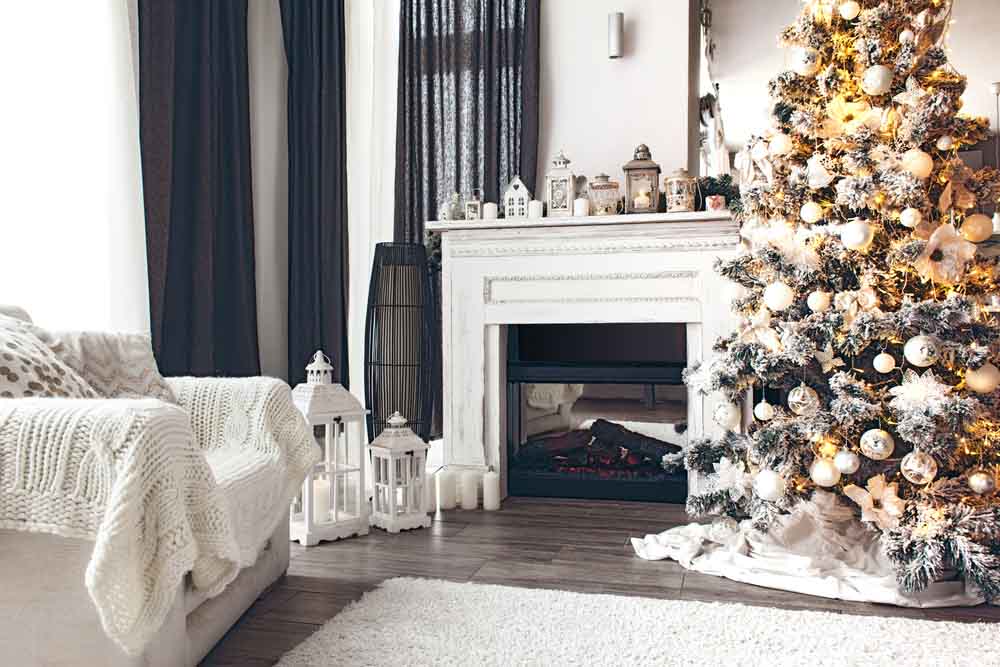 room with Christmas tree, fireplace and armchair